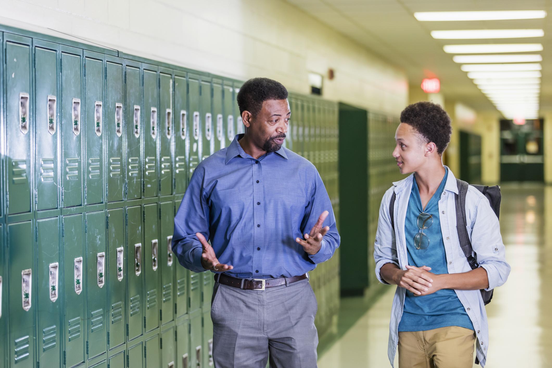 principal talking to student in hallway